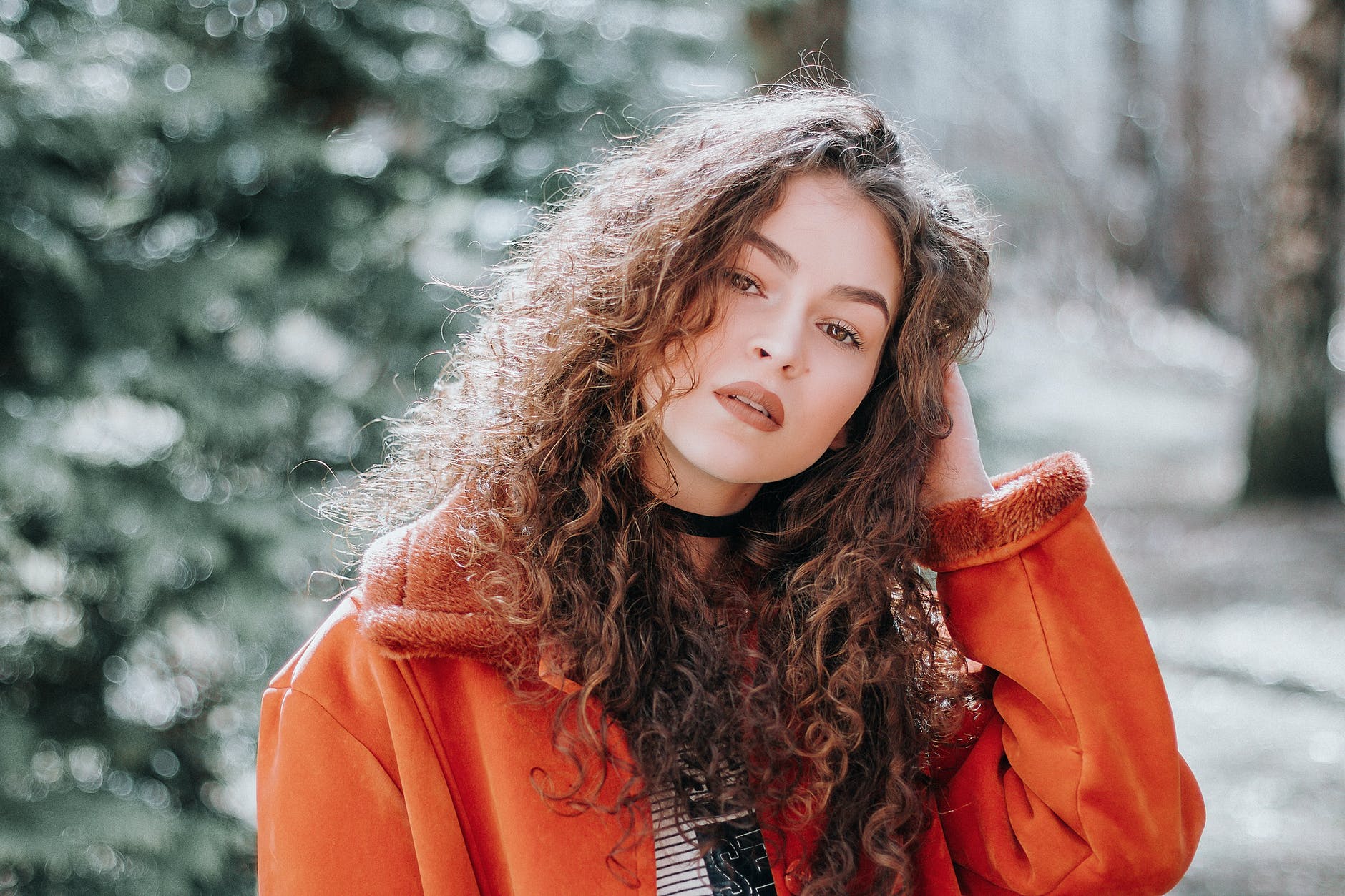 curly hair woman in orange zip up jacket